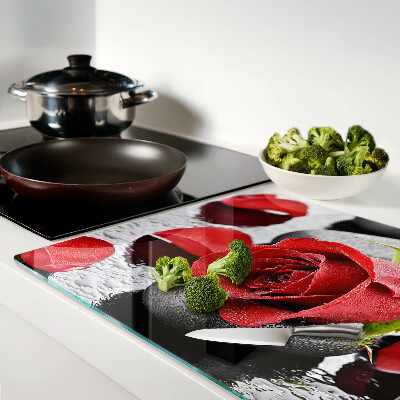 Snijplanken van glas Roos op stenen met waterdruppels