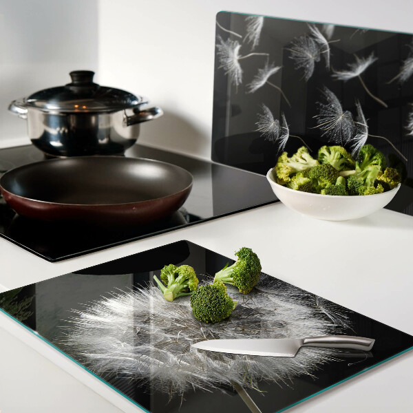 Glazen snijplanken Paardenbloemen op een zwarte achtergrond