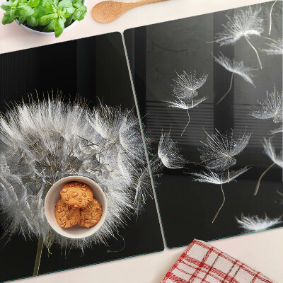 Glazen snijplanken Paardenbloemen op een zwarte achtergrond