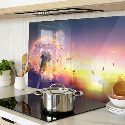 Glazen snijplanken Paardenbloemen tegen de achtergrond van de zonsondergang