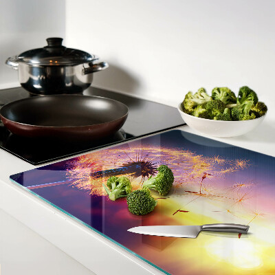 Glazen snijplanken Paardenbloemen tegen de achtergrond van de zonsondergang