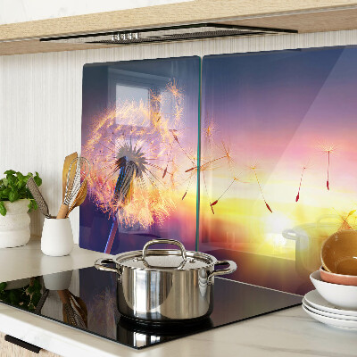 Glazen snijplanken Paardenbloemen tegen de achtergrond van de zonsondergang