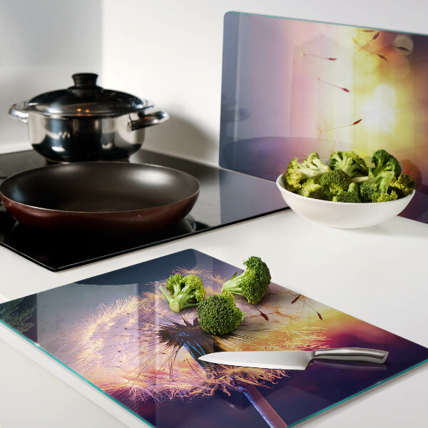 Glazen snijplanken Paardenbloemen tegen de achtergrond van de zonsondergang