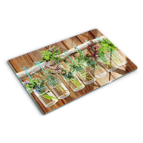 Glazen snijplanken Kruiden in potjes op een houten achtergrond.