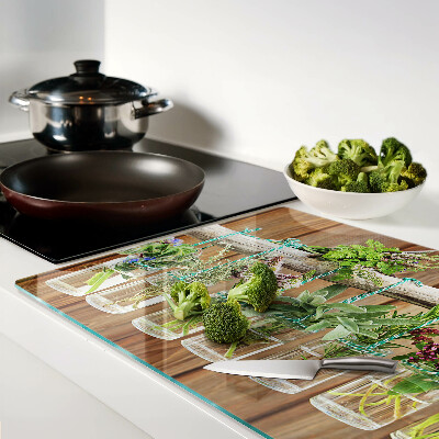 Glazen snijplanken Kruiden in potjes op een houten achtergrond.