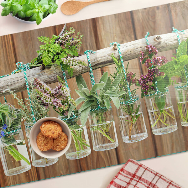 Glazen snijplanken Kruiden in potjes op een houten achtergrond.