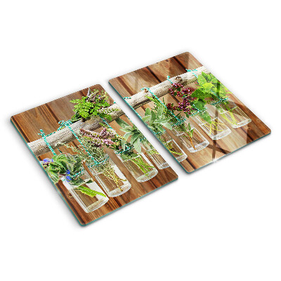 Glazen snijplanken Kruiden in potjes op een houten achtergrond.