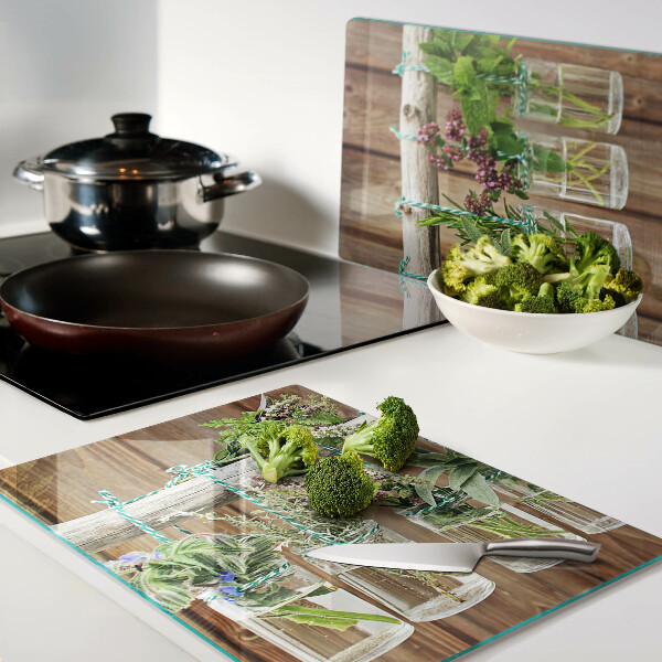 Glazen snijplanken Kruiden in potjes op een houten achtergrond.