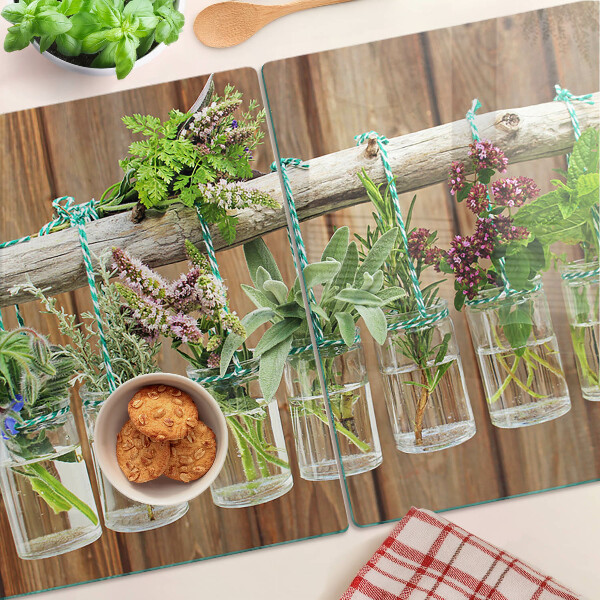 Glazen snijplanken Kruiden in potjes op een houten achtergrond.