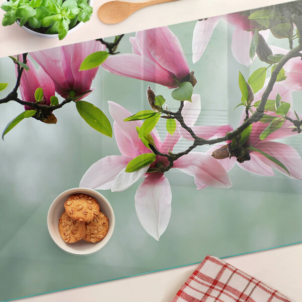 Snijplanken glas Magnoliabloemen tegen een achtergrond van groen.