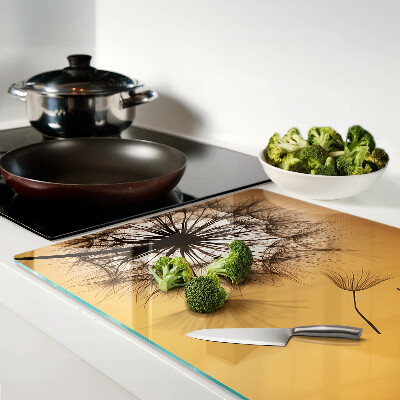 Glazen snijplanken Paardenbloemen tegen de achtergrond van de zonsondergang