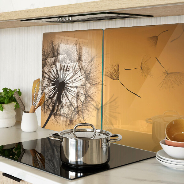 Glazen snijplanken Paardenbloemen tegen de achtergrond van de zonsondergang