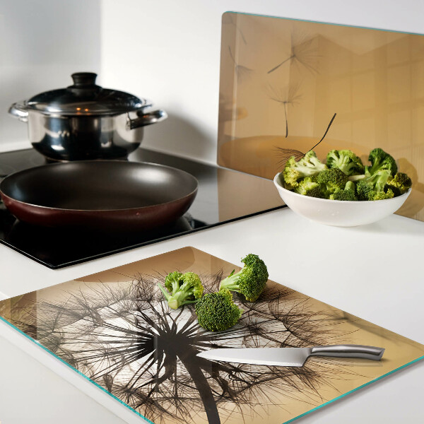 Glazen snijplanken Paardenbloemen tegen de achtergrond van de zonsondergang