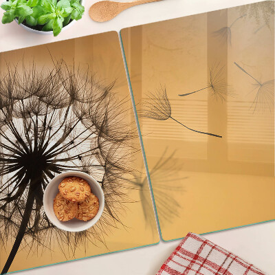 Glazen snijplanken Paardenbloemen tegen de achtergrond van de zonsondergang