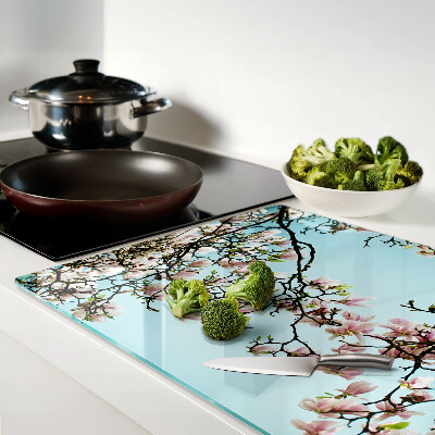 Snijplanken van glas Magnoliabloemen op een blauwe achtergrond