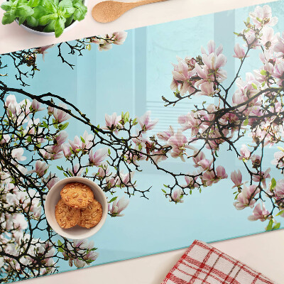 Snijplanken van glas Magnoliabloemen op een blauwe achtergrond