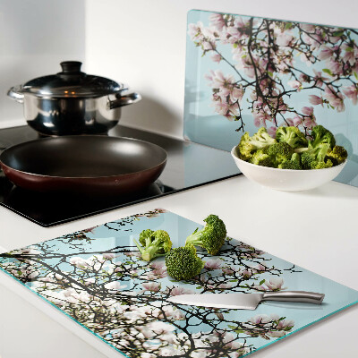 Snijplanken van glas Magnoliabloemen op een blauwe achtergrond