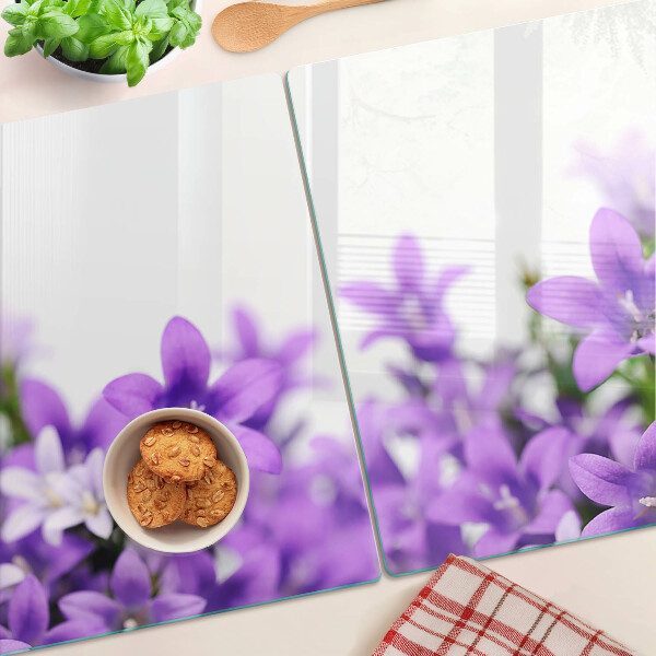 Snijplanken van glas Paarse bloemen op de achtergrond