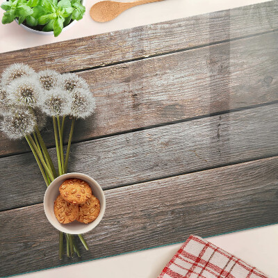 Glazen snijplanken Paardenbloemen op een houten achtergrond