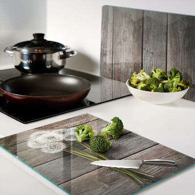 Glazen snijplanken Paardenbloemen op een houten achtergrond