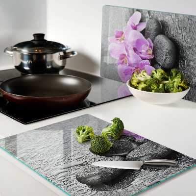 Snijplanken glas Bloemen en stenen tegen een achtergrond van water.