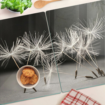 Snijplanken van glas Pluizige paardenbloemen op een monochrome achtergrond.