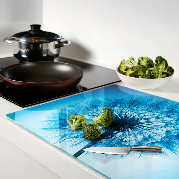 Snijplanken van glas Paardenbloem op een blauwe achtergrond