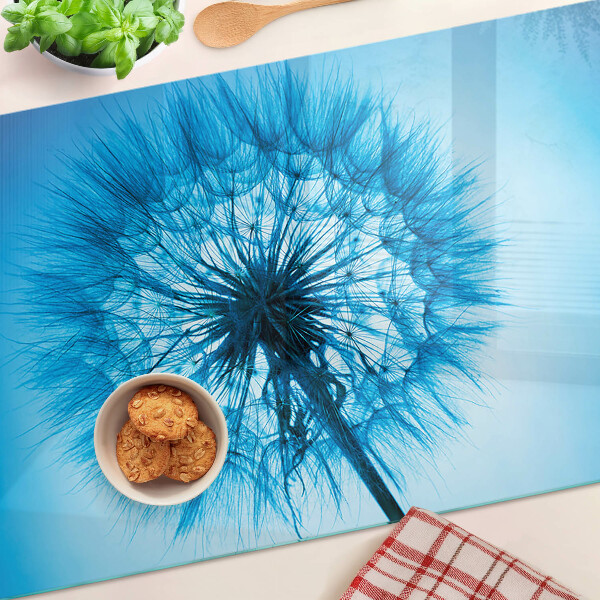 Snijplanken van glas Paardenbloem op een blauwe achtergrond