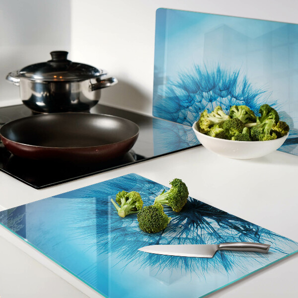 Snijplanken van glas Paardenbloem op een blauwe achtergrond