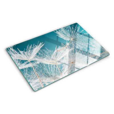 Snijplanken van glas Paardenbloemen op een blauwe achtergrond