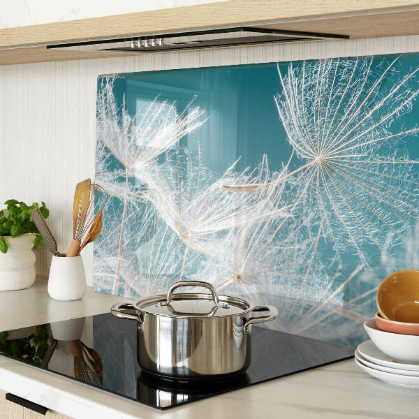 Snijplanken van glas Paardenbloemen op een blauwe achtergrond