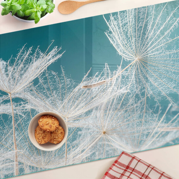 Snijplanken van glas Paardenbloemen op een blauwe achtergrond