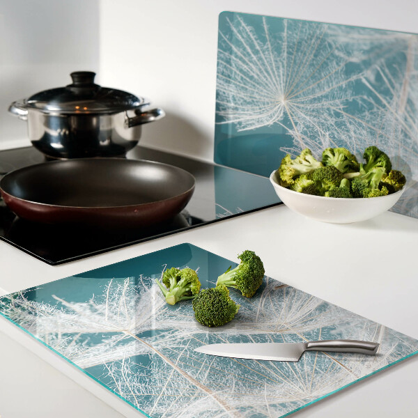 Snijplanken van glas Paardenbloemen op een blauwe achtergrond