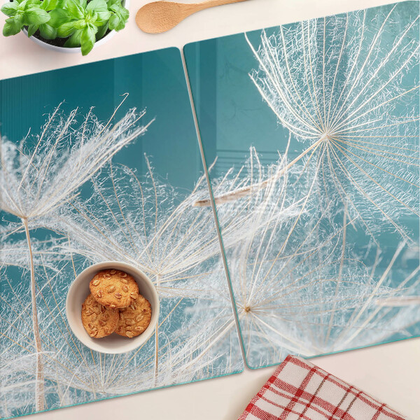 Snijplanken van glas Paardenbloemen op een blauwe achtergrond