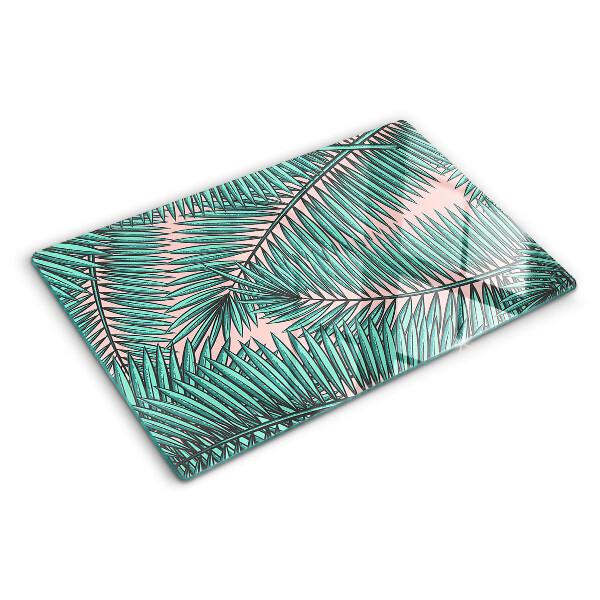 Snijplanken van glas Palmbladeren op een roze achtergrond