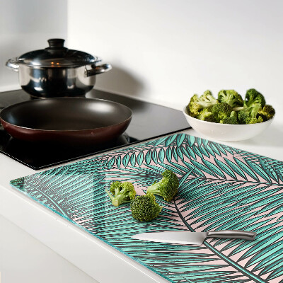 Snijplanken van glas Palmbladeren op een roze achtergrond