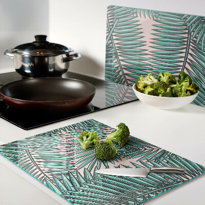 Snijplanken van glas Palmbladeren op een roze achtergrond