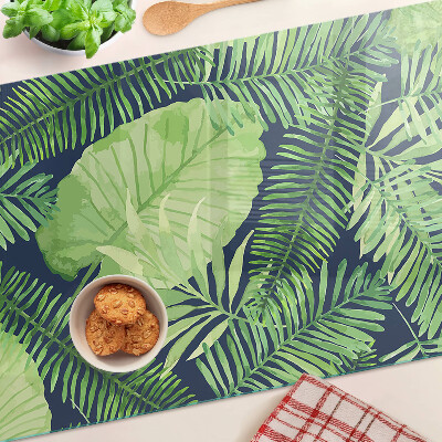 Snijplanken van glas Tropische bladeren op een donkere achtergrond