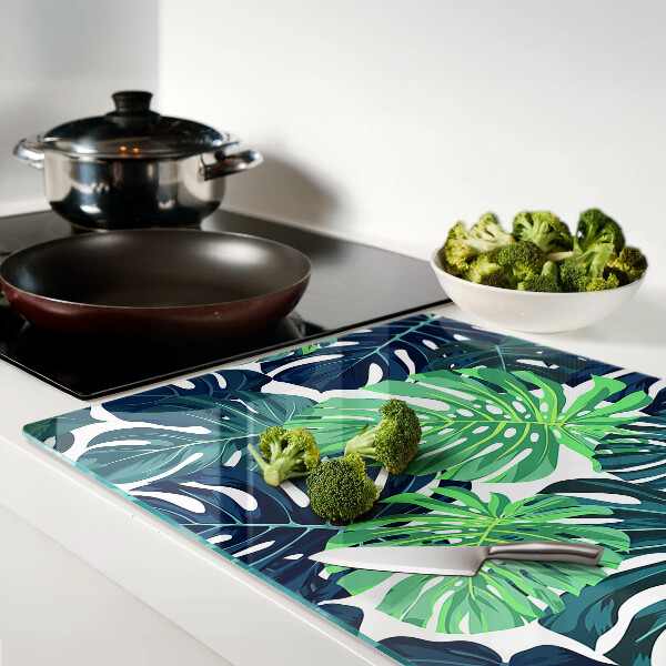 Glazen snijplanken Monstera-bladeren op een tropische achtergrond