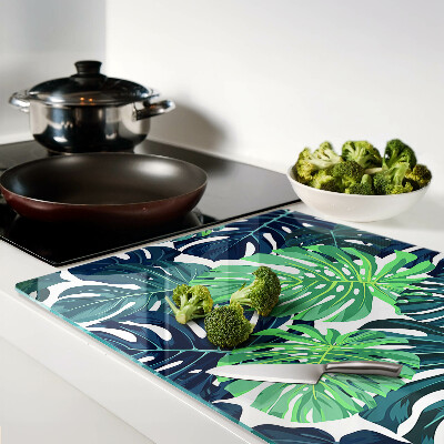 Glazen snijplanken Monstera-bladeren op een tropische achtergrond