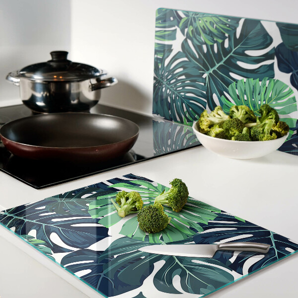 Glazen snijplanken Monstera-bladeren op een tropische achtergrond