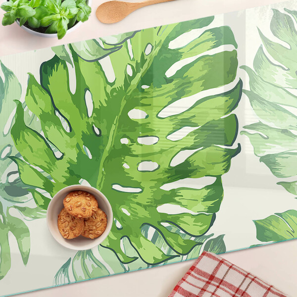 Snijplanken glas Monstera-bladeren op een lichte achtergrond