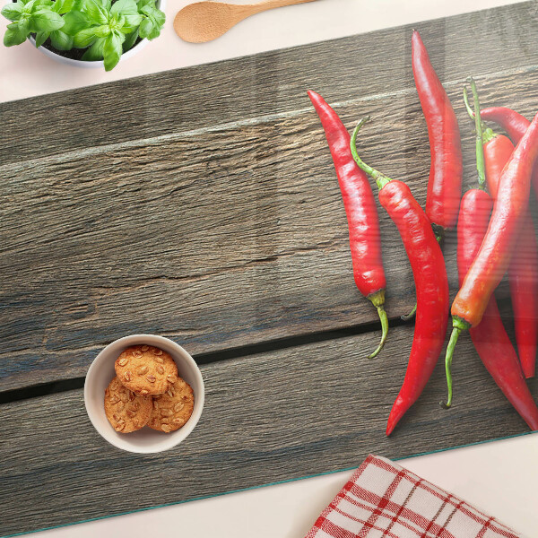 Glazen snijplanken Chilipepers op een houten achtergrond