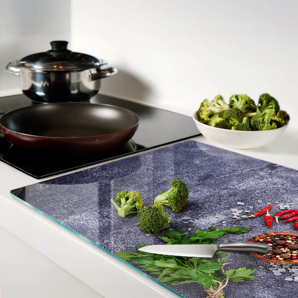 Glazen snijplanken Kruiden en specerijen op een stenen achtergrond