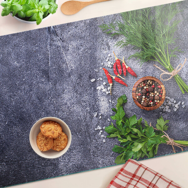 Glazen snijplanken Kruiden en specerijen op een stenen achtergrond