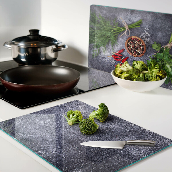 Glazen snijplanken Kruiden en specerijen op een stenen achtergrond