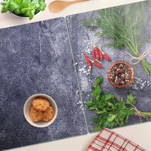 Glazen snijplanken Kruiden en specerijen op een stenen achtergrond