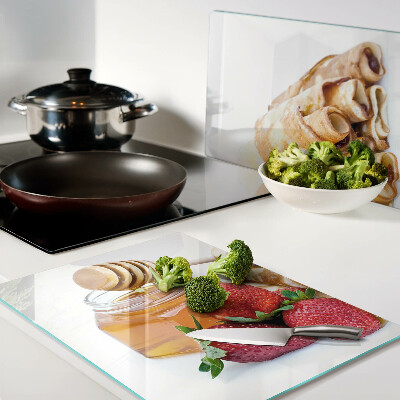 Snijplanken van glas Pannenkoeken met honing en aardbeien