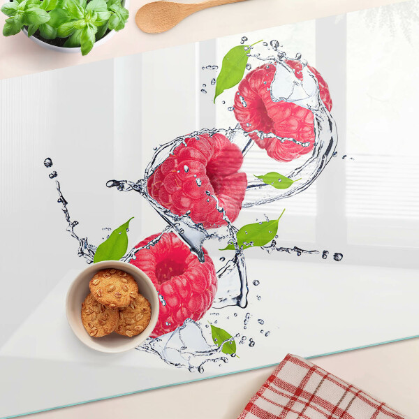 Snijplanken van glas Frambozen in water met bladeren