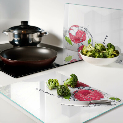 Snijplanken van glas Frambozen in water met bladeren